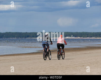 Le couple, méconnaissable, homme et une femme sur un vélo sur la plage Banque D'Images