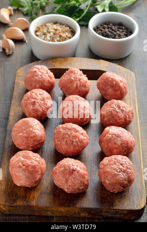 Boulettes de brut sur la planche à découper sur la table en bois Banque D'Images