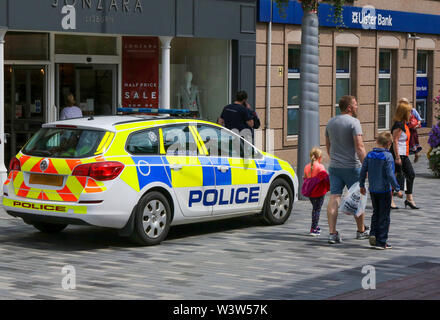 Voiture de police en stationnement PSNI à l'extérieur de l'atelier dans une zone piétonne avec des gens marcher passé sur un après-midi ensoleillé de Lisburn, Irlande du Nord. Usage éditorial onl Banque D'Images