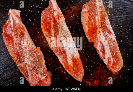 Côtelettes de porc désossées assaisonnées avec tomates séchées, paprika rouge Banque D'Images