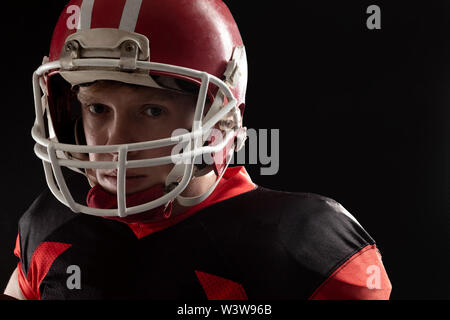 Joueur de football américain dans l'article casque sur fond noir Banque D'Images