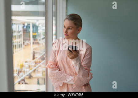 Thoughtful Businesswoman standing dans la salle de conférence au bureau Banque D'Images