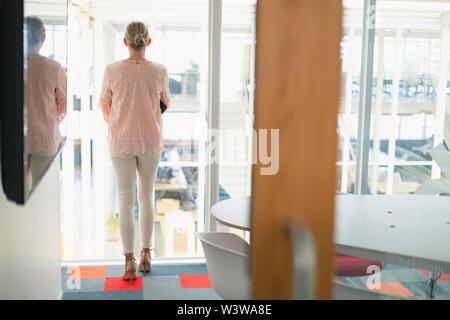 Thoughtful Businesswoman standing dans la salle de conférence au bureau Banque D'Images