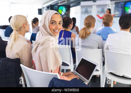 Happy Businesswoman using laptop au cours de séminaire d'entreprise Banque D'Images