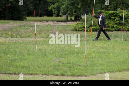 16 juillet 2019, Saxe, Wermsdorf : Un assistant de l'action enjeux artiste Witthaus les lignes de l'ancien jardin baroque dans les prés, dans le parc du château de Hubertusburg. Le plus grand pavillon de chasse a retourné une fraction de son jardin perdu. Avec environ 40 bénévoles, l'action de Cologne artiste a cut gratuitement quelques-unes des formes de bijoux dans l'ancien parc depuis le 1er juillet. Sur 10 000 mètres carrés, l'axe central et le centre du jardin baroque composition ont été ressuscités - un dixième de l'ancien complexe. Mais les visiteurs à l'axone 'Versailles' faut se dépêcher, car il Banque D'Images