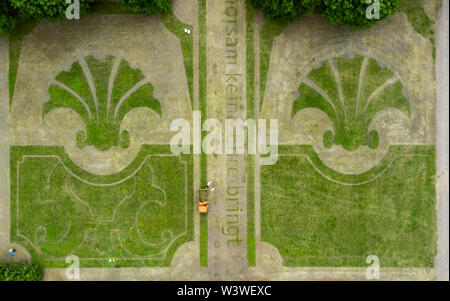 16 juillet 2019, Saxe, Wermsdorf : des assistants de l'artiste action Witthaus tondre les lignes de l'ancien jardin baroque dans les prés dans le parc du château de Hubertusburg, enregistré à l'aide d'un drone. Le plus grand pavillon de chasse a retourné une fraction de son jardin perdu. Avec environ 40 bénévoles, l'action de Cologne artiste a cut gratuitement quelques-unes des formes de bijoux dans l'ancien parc depuis le 1er juillet. Sur 10 000 mètres carrés, l'axe central et le centre du jardin baroque composition ont été ressuscités - un dixième de l'ancien complexe. Mais les visiteurs à l'axone 'Versailles' ont à Banque D'Images