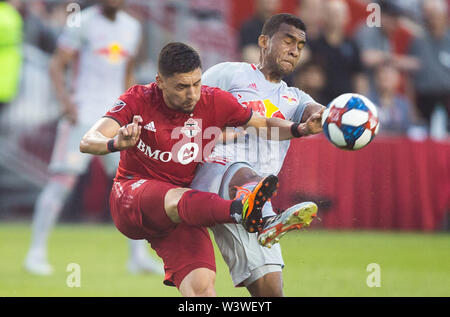 Toronto, Canada. 17 juillet, 2019. Marco Delgado(L) de Toronto FC rivalise avec Cristian Casseres Jr. de New York Red Bulls lors de leur 2019 Major League Soccer (MLS) correspondent au BMO Field à Toronto, Canada, le 17 juillet 2019. Le Toronto FC a gagné 3-1. Credit : Zou Zheng/Xinhua/Alamy Live News Banque D'Images