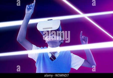 Image composite de l'écolier le port de casque de réalité virtuelle bénéficiant Banque D'Images