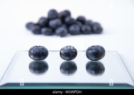 Les bleuets sucrés - Tas de myrtilles fraîchement récoltés sur un fond blanc - Grand, sweet humide les bleuets sur une plaque de verre - Close-up Banque D'Images