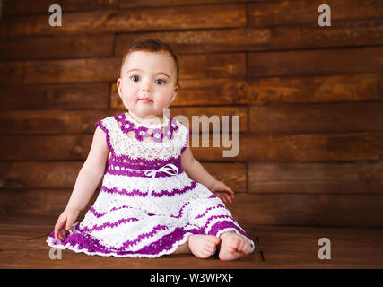 Cute little girl sur un fond de bois. Banque D'Images