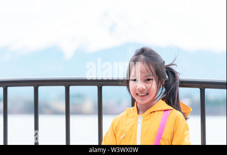 Kid est debout devant le lac Kawaguchiko et le mont Fuji en hiver. Banque D'Images