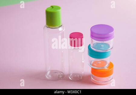 Taille de voyage et cosmétiques flacons crèmes situé sur fond rose. Le minimalisme cosmétiques style. Haut de la vue, télévision lay. Banque D'Images