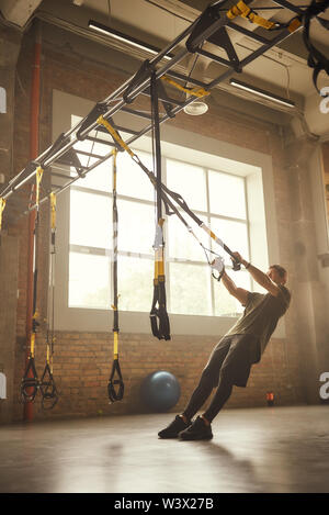 Strong athletic man training ses bras avec trx sangles remise en forme à la salle de sport. Formation TRX. Concept d'entraînement. Banque D'Images