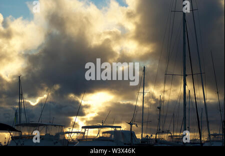 Coucher de soleil éclate de façon spectaculaire grâce à l'assombrissement de nuages de pluie plus de yachts dans une marina sur la côte ouest de l'Australie Banque D'Images