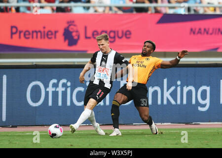 Matt Ritchie de Newcastle United, gauche, défis Adama Traore de Wolverhampton Wanderers durant leur Premier League Trophy Asie demi-finale à Shanghai, la Chine de l'est de la province de Jiangsu, le 17 juillet 2019. Banque D'Images