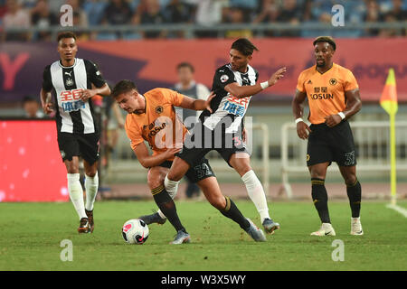 Joueur de football belge Leander Dendoncker, gauche, de Wolverhampton Wanderers F.C. de champions de la Ligue anglaise passe le ballon contre un joueur de Newcastle United Football Club en demi-finale au cours de la Premier League Trophy 2019 l'Asie à Nanjing city, Jiangsu province de Chine orientale, le 17 juillet 2019. Wolverhampton Wanderers F.C. défait Newcastle United F.C. 4-0. Banque D'Images