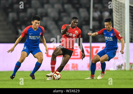 Joueur de football camerounais Jean Marie, centre de Shenzhen, C.F. passe le ballon contre des joueurs de Chongqing GDS en leur 18e match au cours de l'Association de football chinoise 2019 Super League (CSL) dans la ville de Shenzhen, province du Guangdong en Chine du Sud, 17 juillet 2019. Chongqing SWM défait Shenzhen C.F. 2-0. Banque D'Images