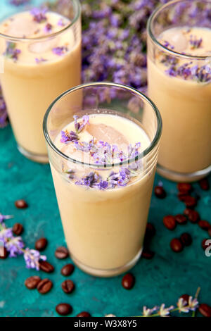 Boisson d'été café glacé à la lavande dans le verre et les grains de café sur fond vert. Bon matin concept. Baeutiful café glace. Banque D'Images