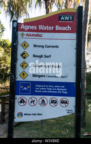 Une plage nageurs warning sign on la longue et large plage de côte au Agnes Water, une petite ville et station balnéaire populaire sur la côte tropicale de la Qu Banque D'Images