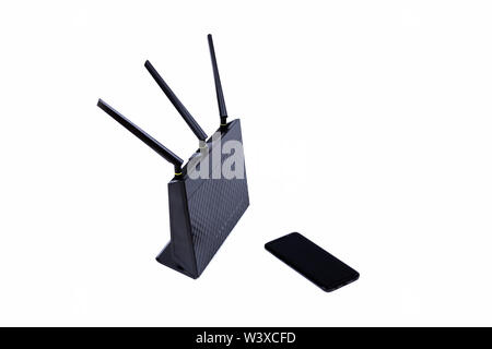 Routeur Wifi sans fil noir modem câble et un smartphone sans nom moderne isolé sur blanc. La connectivité Internet et de topologie réseau simple général Banque D'Images