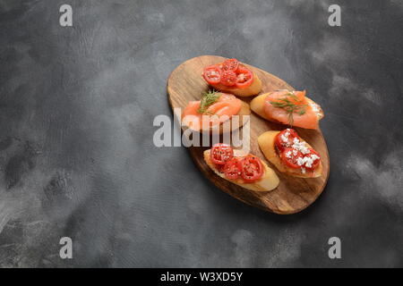 Brushetta ou des tapas espagnoles traditionnelles. Hors-d'antipasti italiens avec des collations. Variété de petits sandwiches avec tomates cerises, saumon, Banque D'Images