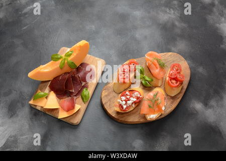 Brushetta ou des tapas espagnoles traditionnelles. Hors-d'antipasti italiens avec des collations. Variété de petits sandwiches avec tomates cerises, saumon, Banque D'Images