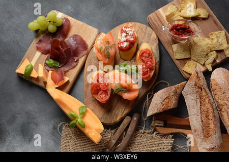 Brushetta ou des tapas espagnoles traditionnelles. Hors-d'antipasti italiens avec des collations. Variété de petits sandwiches avec tomates cerises, saumon, Banque D'Images