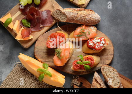 Brushetta ou des tapas espagnoles traditionnelles. Hors-d'antipasti italiens avec des collations. Variété de petits sandwiches avec tomates cerises, saumon, Banque D'Images