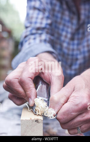 Close up of mans mains travailler avec un avion sur planche en bois Banque D'Images