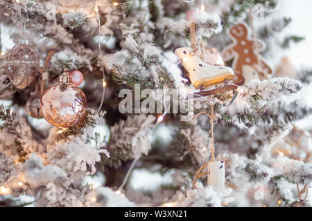 Bal de Noël et jouets suspendus patins sur l'arbre avec de la neige artificielle Banque D'Images