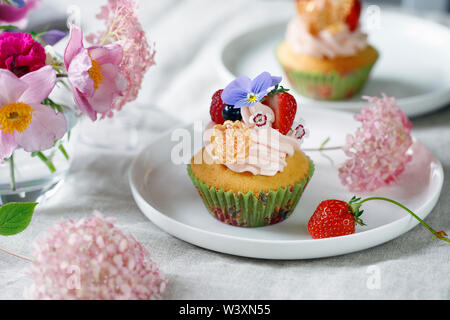 Décorées avec Cupcake buttercream, fruits et fleurs Banque D'Images