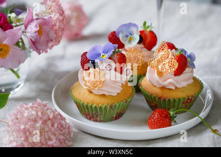 Décorées avec Cupcake buttercream, fruits et fleurs Banque D'Images
