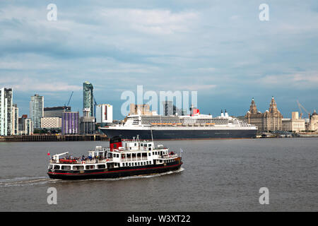 Le Mersey Ferry Iris Royal passant devant le Queen Mary 2 fait escale à Liverpool en juillet 2019. Banque D'Images