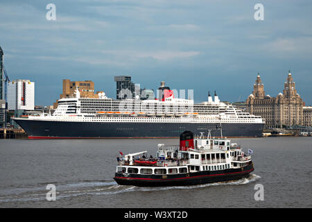 Le Mersey Ferry Iris Royal passant devant le Queen Mary 2 fait escale à Liverpool en juillet 2019. Banque D'Images