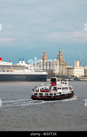 Le Mersey Ferry Iris Royal passant devant le Queen Mary 2 fait escale à Liverpool en juillet 2019. Banque D'Images