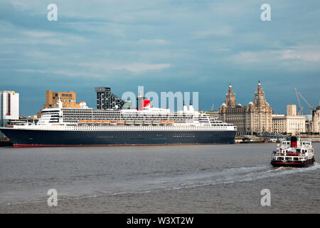 Le Mersey Ferry Iris Royal passant devant le Queen Mary 2 fait escale à Liverpool en juillet 2019. Banque D'Images