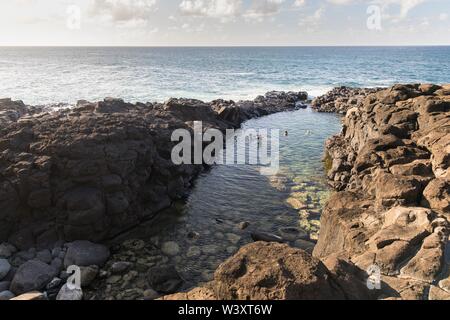 Imprimeur de la baignoire a une marée intérieure entre la roche volcanique à la plage dans Princeville Kauai, Hawaii, USA, populaire parmi les touristes mais dangereuse pendant la mer difficile Banque D'Images