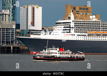 Le Mersey Ferry Iris Royal passant devant le Queen Mary 2 fait escale à Liverpool en juillet 2019. Banque D'Images