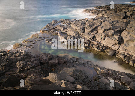 Imprimeur de la baignoire a une marée intérieure entre la roche volcanique à la plage dans Princeville Kauai, Hawaii, USA, populaire parmi les touristes mais dangereuse pendant la mer difficile Banque D'Images