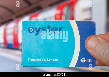 Londres, Royaume-Uni - 18 juillet 2019 - Londres passager Tube hol une carte Oyster devant le métro. Banque D'Images