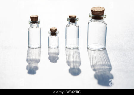 Ensemble de petites bouteilles avec grande ombre sur fond blanc Banque D'Images