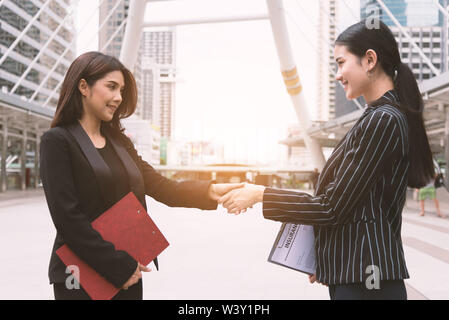 Deux femmes faisant l'autre message d'handshake en réunion à l'extérieur. Les gens d'affaires et de faire face contrat. L'amitié et de concept de leadership. Banque D'Images
