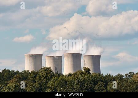 Avis de fumeurs cheminées de centrale nucléaire, les lignes d'alimentation et de la forêt, sous ciel bleu avec des nuages blancs Banque D'Images