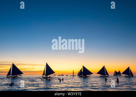 Voiliers au coucher du soleil sur la plage blanche, l'île de Boracay, Province d'Aklan, Western Visayas, Philippines Banque D'Images