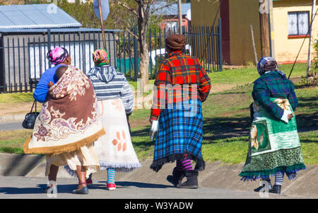 Quatre femmes d'Afrique noire d'origine Basotho enveloppé dans un style traditionnel des couvertures à pied dans une rue à Clarens, Orange Free State, Afrique du Sud Banque D'Images