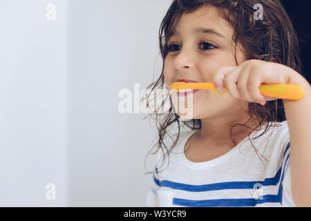 Portrait d'une petite fille se brosser les dents dans la salle de bains avant d'aller au lit après la douche, pour les enfants, copie espace concept d'hygiène pour le texte Banque D'Images