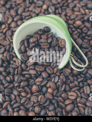 Bol vert parmi un lot de grains de café. Banque D'Images