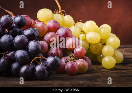 Grappes de raisin de différents types sur une table en bois Banque D'Images