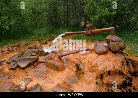 Source de l'eau Narzan ressort avec haute teneur en fer qui lui donne une couleur orange rouille, largement connu pour les qualités de guérison de l'eau minérale le long de la rivière situé dans Hasaut Kabardino-balkarie dans le District fédéral du Caucase du Nord de la Russie Banque D'Images