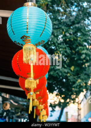 Lanternes de papier chinois sur l'oscillation de vent sur le toit d'un bâtiment par jour dans la rue Banque D'Images